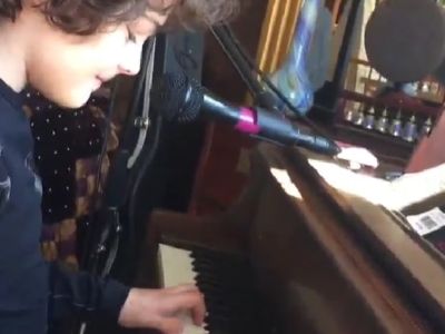 Hayden Rolence has a smile on his face as he is playing the piano.